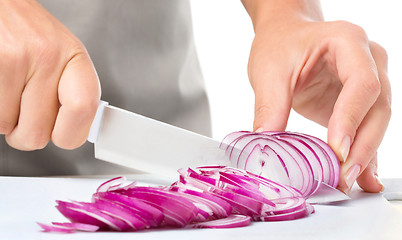 Image showing Cook is chopping onion