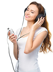 Image showing Young woman enjoying music using headphones