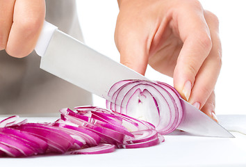 Image showing Cook is chopping onion