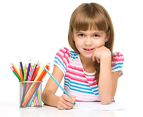 Image showing Little girl is drawing using pencils