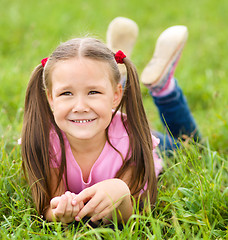Image showing Portrait of a little girl laying on green grass