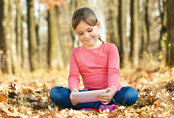 Image showing Little girl is reading from tablet