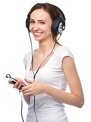 Image showing Young woman enjoying music using headphones