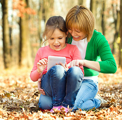 Image showing Mother is reading from tablet with her daughter