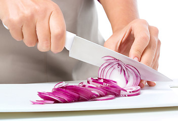 Image showing Cook is chopping onion