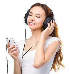 Image showing Young woman enjoying music using headphones