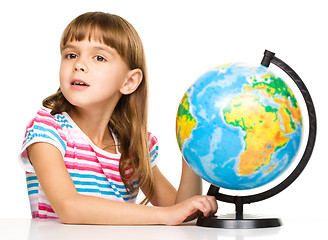 Image showing Little girl is examining globe