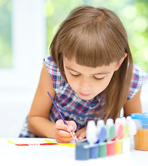 Image showing Little girl is painting with gouache