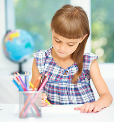 Image showing Little girl is drawing using pencils