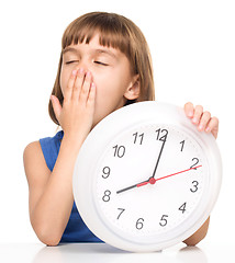 Image showing Little girl is holding big clock