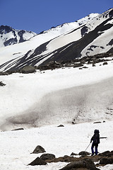 Image showing Hiker in snowy mountains at spring