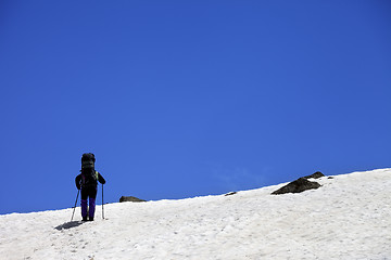 Image showing Hiker in snowy mountains at spring