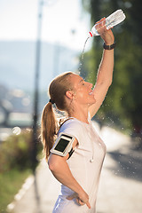 Image showing woman drinking  water after  jogging