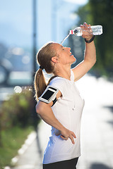 Image showing woman drinking  water after  jogging