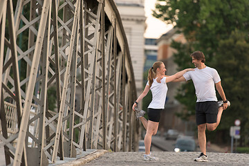 Image showing couple warming up and stretching before jogging