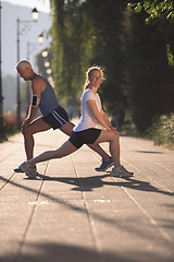 Image showing couple warming up and stretching before jogging