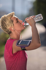 Image showing woman drinking  water after  jogging