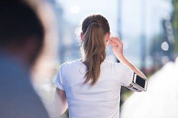 Image showing jogging woman setting phone before jogging