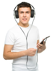 Image showing Young man enjoying music using headphones