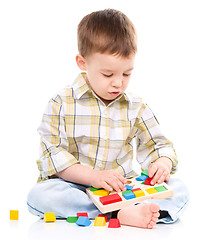 Image showing Little boy is playing with toys