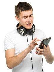 Image showing Young man enjoying music using headphones