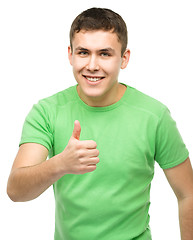 Image showing Cheerful young man showing thumb up sign