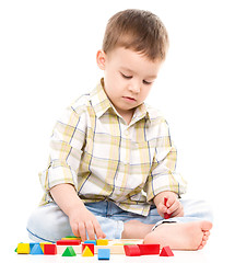 Image showing Little boy is playing with toys