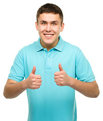 Image showing Cheerful young man showing thumb up sign