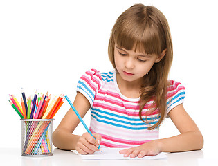 Image showing Little girl is drawing using pencils