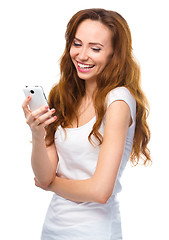 Image showing Young woman is pleased by incoming message