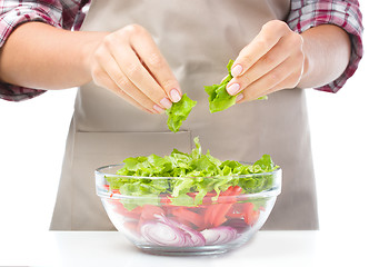 Image showing Cook is tearing lettuce while making salad