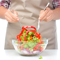 Image showing Cook is mixing salad