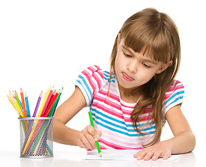 Image showing Little girl is drawing using pencils