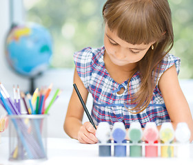 Image showing Little girl is painting with gouache