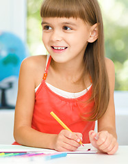 Image showing Little girl is drawing using pencils