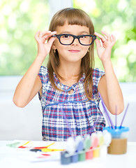 Image showing Little girl is painting with gouache