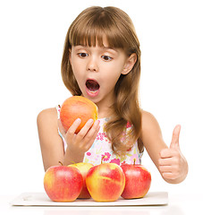 Image showing Little girl with apples is showing thumb up sign