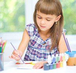 Image showing Little girl is painting with gouache