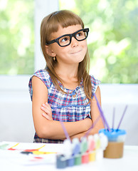 Image showing Little girl is painting with gouache