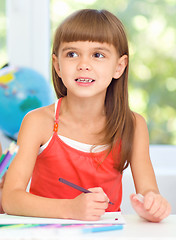 Image showing Little girl is drawing using pencils