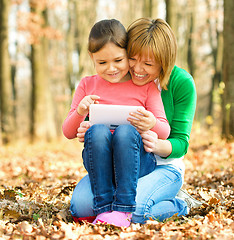 Image showing Mother and her daughter is playing with tablet