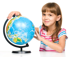 Image showing Little girl is examining globe