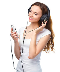 Image showing Young woman enjoying music using headphones