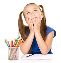 Image showing Girl is daydreaming while drawing with pencils