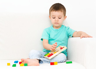 Image showing Boy is playing with puzzle