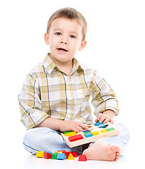 Image showing Little boy is playing with toys