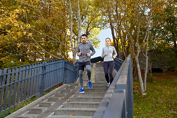 Image showing happy couple running downstairs in city