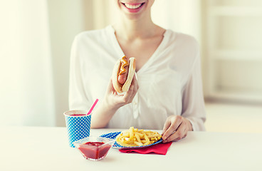 Image showing close up of woman eating hotdog and french fries