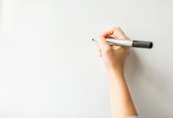 Image showing close up of hand writing something on white board