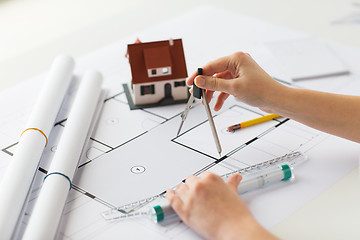 Image showing close up of hands with compass measuring blueprint